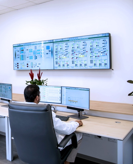 Tecnico di Acea Ato 5 monitora quattro schermi e un grande pannello di controllo sul muro