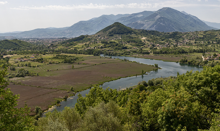 Panorama naturale con il fiume che attraversa la pianura coltivata