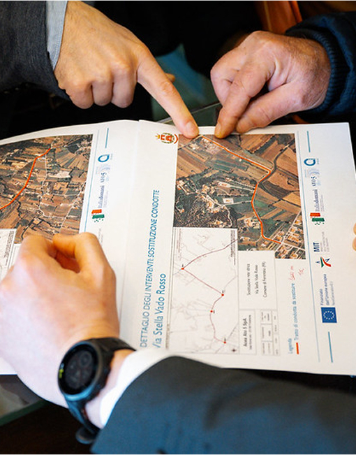 Mani di due persone che indicano dettagli su una mappa cartacea